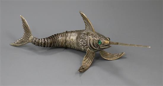 A Spanish white metal articulated free-standing model of a swordfish with green cabochon stone eyes, approx. 19cm.